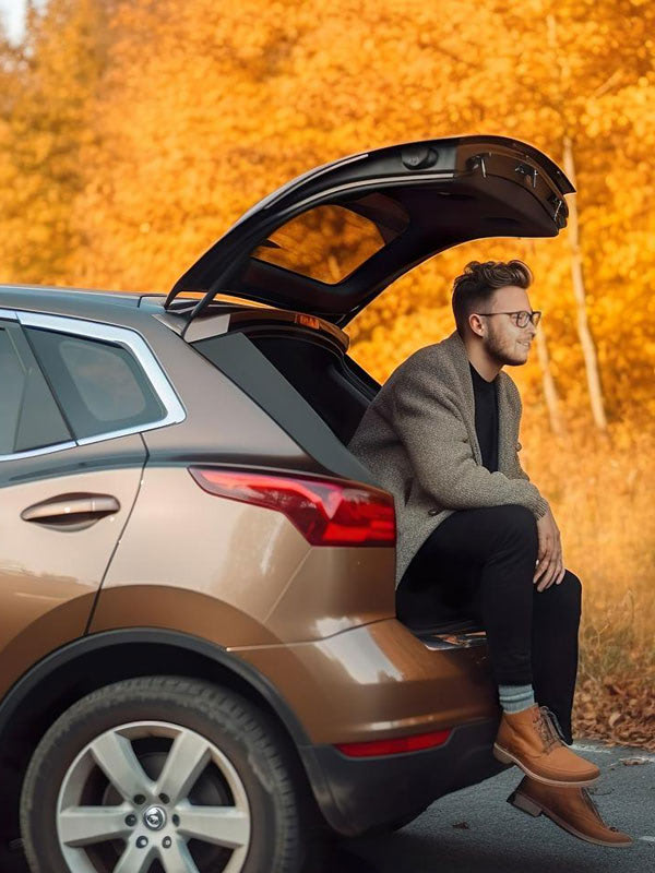 The driver is sitting on the boot.